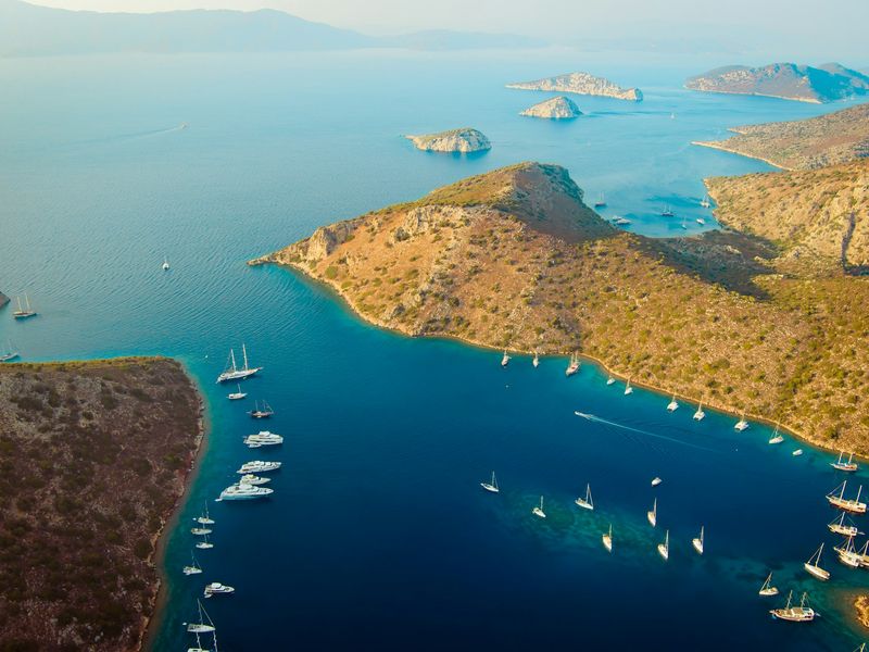 A serene view of Marmaris, showcasing its tranquil blue waters surrounded by lush green hills.